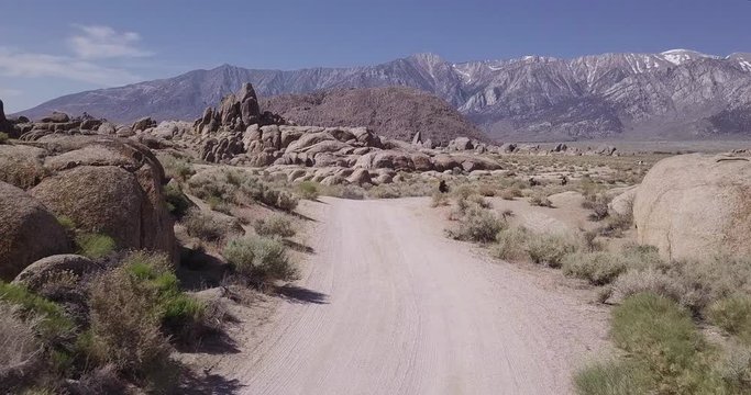 bikers riding choppers on the dusty road of Alabama hills, Lone pine, California. Aerial shot,drone following the road