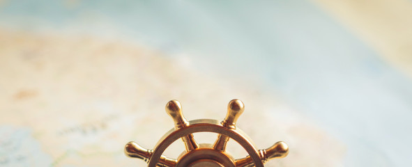 Part of a small marine steering wheel on a background of blurred cards.