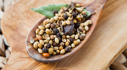Whole Garam Masala -  Indian Spices on wooden spoon.