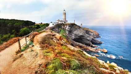 Fototapeta na wymiar Hermoso paisaje de playa y costa con montañas y vegetación. Acantilados en Cantabria, Cabo Mayor Lighthouse en Santander, España.