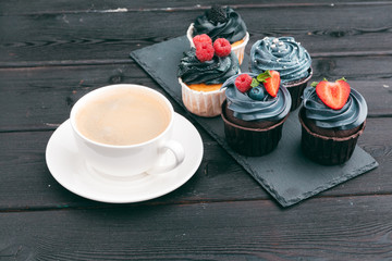 Set of different delicious cupcakes on dark
