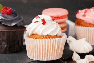 Delicious raspberry and caramel cupcakes on dark background
