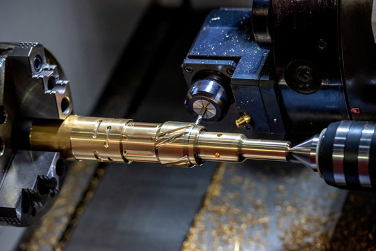 The CNC lathe machine cutting the slot groove by milling turret. The metal working operation by turning machine cutting the groove the brass shaft.