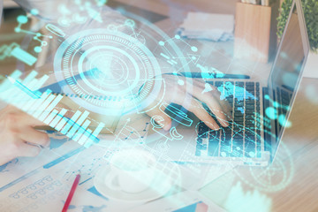 Double exposure of businessman working on laptop on background. International business hologram in front. Concept of success.
