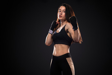 Sportsman, woman boxer fighting in gloves on black background. Boxing and fitness concept.