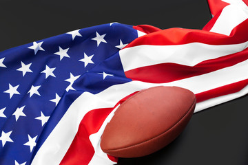 American football ball and american flag on table close up