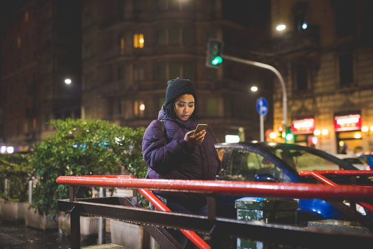 portrait of young african woman using smartphone close to metro station