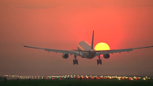 Airplane crossing the sun at sunrise