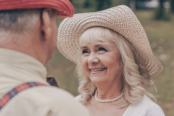 Close up portrait of a happy couple. Grandmother in a hat smiling grandparents. Looking into each other's eyes. Happy old age concept. Memories of his youth and nastalgiya