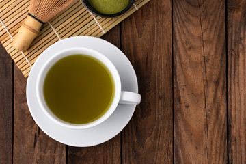 hot green tea in cup on wood