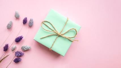 Obraz na płótnie Canvas Green gift box with ribbon on a pink background .