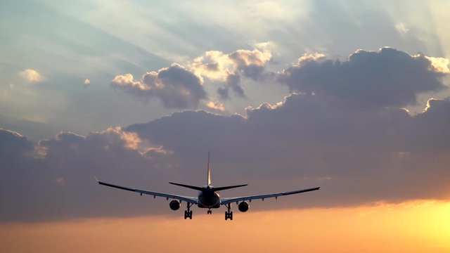 Tracking shot of airplane landing in beautiful morning sky