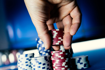 Lucky player stacking poker chips at casino