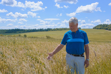 Naklejka na ściany i meble happy old elderly male standing in wheat fields. Healthcare lifestyle senior man walking on field in village.