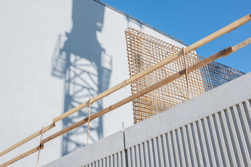 Shadow of a crane on a white building. Seen elements of construction.