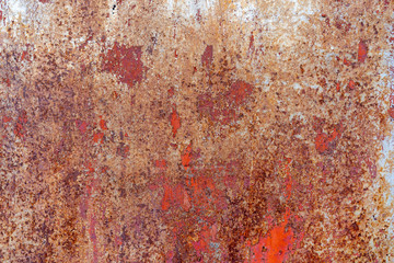 Background peeling red paint on a metal surface. Old painted metal door. Orange Paint is ripped off...