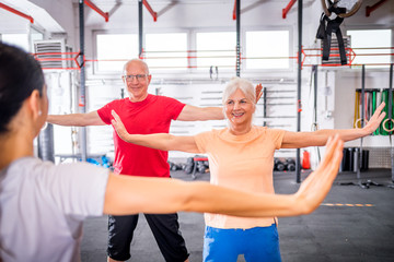 Senior people workout with personal trainer in rehabilitation center