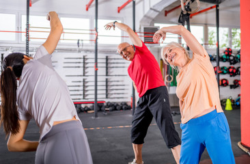 Fototapeta na wymiar Senior people workout with personal trainer in rehabilitation center