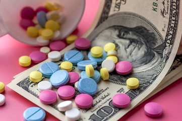 Different Multicolored Pills on One Hundred Dollar Bills