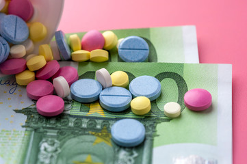 Different Multicolored Pills on One Hundred Euro Bills