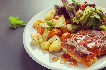 Fish fillet baked with cheese with potatoes, sweet potatoes, carrots and greens and vegetables mix. Fresh Salt dressing seasoned and sprinkled with sesame