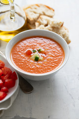 typical spanish cold spup gazpacho in white bowl on cermic background