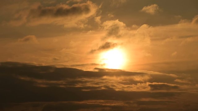 Superzoom plan timelapse sunset through sunset clouds in orange tones. Low key