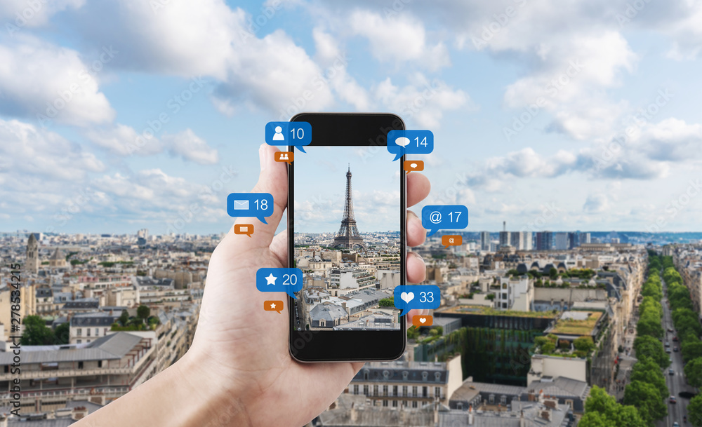 Poster hand using mobile smart phone taking photo of eiffel tower in paris, france with social media and so
