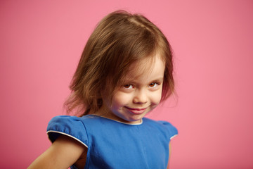 Shy little girl with cute look, portrait on pink isolated background.