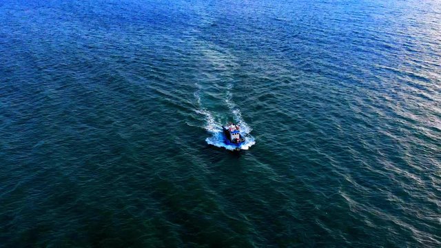 Amazing rotating aerial of boat splitting through the open ocean waters