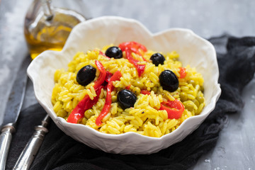 rice with vegetables and black olives in beautiful dish