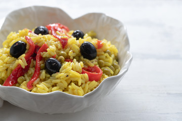 rice with vegetables and black olives in beautiful dish