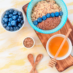 Healthy breakfast ingredients. Buckwheat blueberries mint honey on white wooden background, top view, copy space