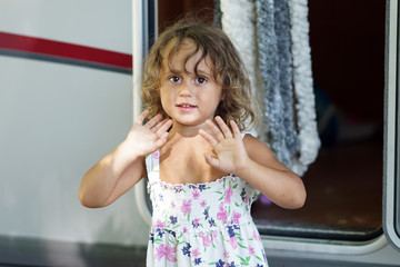 A three-year-old blond girl gestures with her hands