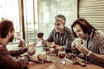 Relaxed male person having dinner with his friends