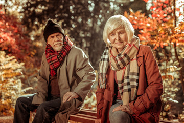 Sad elderly woman sitting on a bench.