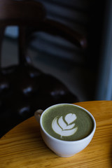 match Latte with beautiful latte art and croissant on dark background on the table. Perfect breacfast in the morning.