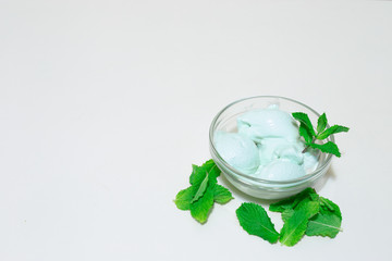 Green tropical ice cream with mine leaves on white background with copy space – Natural iced creamy refreshment made at home – Healthy sweet and tasty cold snack