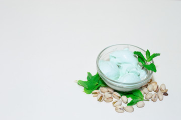 Pistachio and mint green ice cream on whit background with copy space – homemade cold desert with nut flavor – Frozen sweet and healthy refreshment