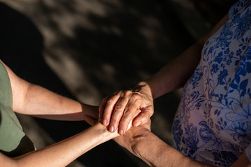 Mother and daughter holding their hands in the sunlight – Concept of parents that spend time with their children