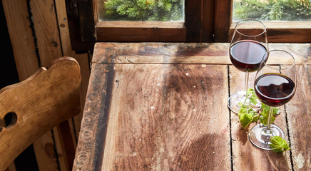 Two glasses of red wine on a rustic table