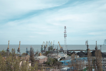 working cranes in the port in cloudy weather. The work of the industrial port in gray weather.