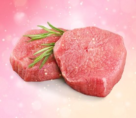 Pieces of fresh meat with a sprig of rosemary on a colorful background