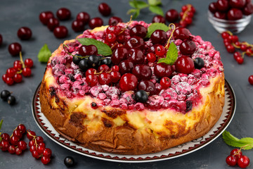 Summer cottage cheese cake with berries located on a dark background, horizontal photo