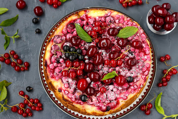 Summer cottage cheese cake with berries located on a dark background, horizontal photo
