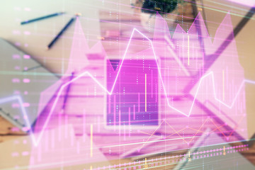 Double exposure of forex graph on digital tablet laying on table background. Concept of market analysis