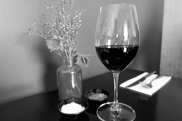Glass of red wine on table in black and white