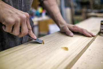 Putty knife in man hand. Removing holes from a wood surface. Preparation of boards before...