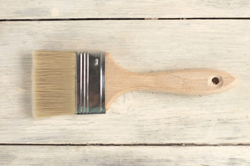 Paint brush on old white vintage wooden plank table. Place for text or logo