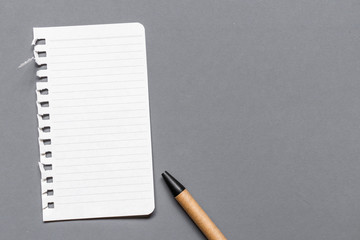 Empty paper sheet with white texture and pink paper clip on gray background surface. Copy space for add text or art work designs.